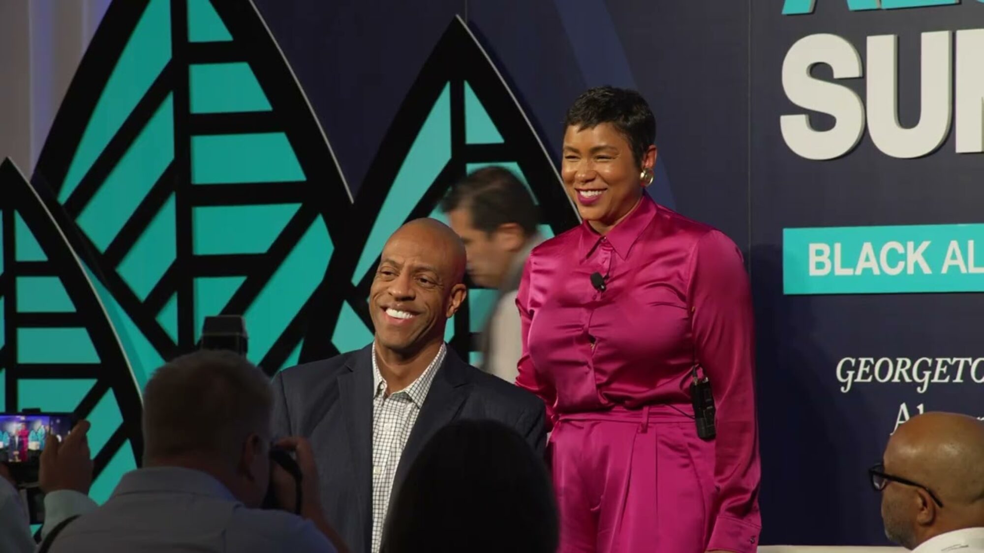 attendees of black alumni summit smiling and posing in front of a bright background